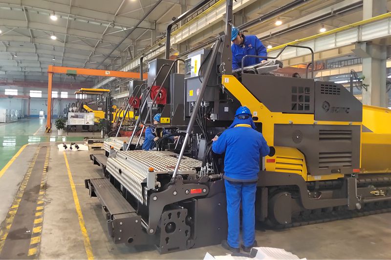 011738395779745128.jpeg 1、工人們抓緊時間總裝即將出口的瀝青混凝土攤鋪機.jpg